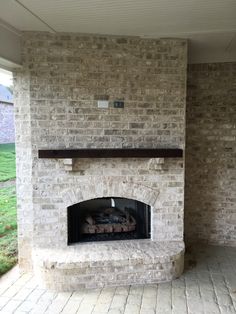 an outdoor fireplace with brick walls and tile flooring