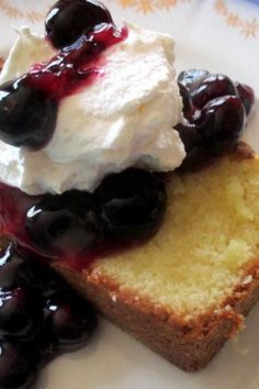 a piece of bread with blueberries and whipped cream on it sitting on a plate