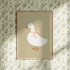 a white duck with a pink bow on it's neck sitting in front of a wall