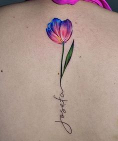 the back of a woman's shoulder with a flower on it and her name written in cursive writing