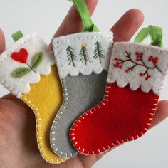 hand holding three felt christmas stockings ornament