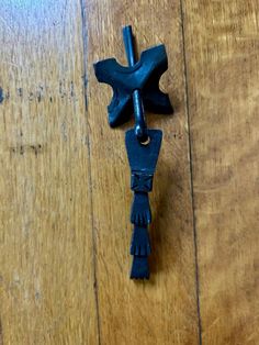 an iron cross hanging on the side of a wooden floor