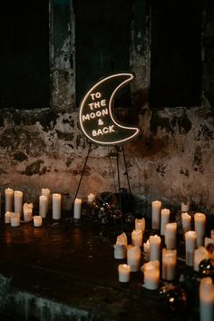 candles are arranged in front of a sign that says to the moon back