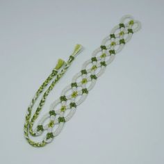 a green and white beaded necklace on a white background