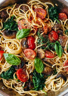 pasta with spinach, mushrooms and tomatoes in a pan