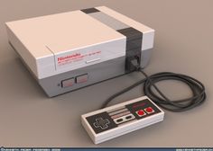 an old nintendo game console and controller sitting next to each other on a table in front of a white box