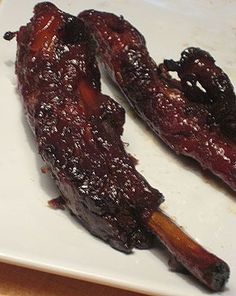 two pieces of meat sitting on top of a white plate