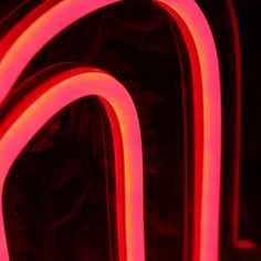 red neon lights are lit up against a black background, creating an abstract pattern in the shape of letters and numbers