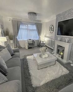 a living room filled with furniture and a flat screen tv mounted on the wall above a fire place