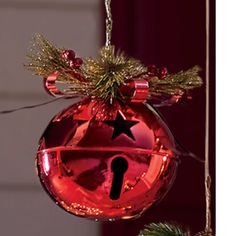 a red ornament hanging from a christmas tree with a black star on it