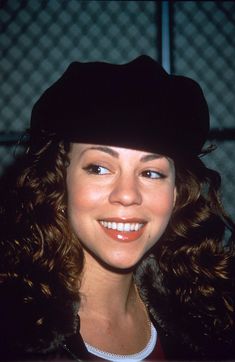 a woman wearing a black hat and smiling