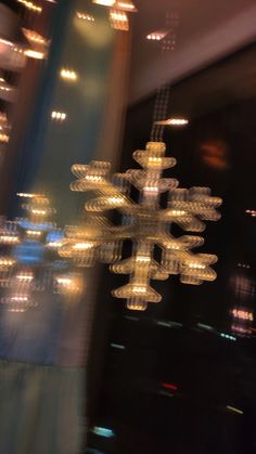 a snowflake is seen through the window of a building in the city at night