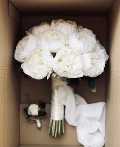 a bouquet of white flowers in a cardboard box