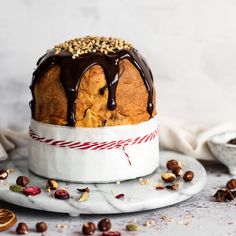 a bundt cake with chocolate drizzled on top and nuts around it