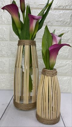 two vases with flowers in them sitting on a table