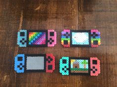 three pieces of colored beads sitting next to each other on a wooden table with the word bead spelled out