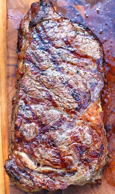 a piece of steak sitting on top of a wooden cutting board