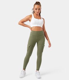 a woman in white top and khaki green cargo leggings standing with her hands on her hips