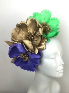 "Magnolia flowers Green gold and purple Fascinator - headband- Nola- New Orleans -Fat Tuesday  Hello,       This magnolia fascinator  is made with 3 color feather (green, gold and purple) about 6\" wide and the centers are hand painted gold.       A few gold lame leaves that have glitter are shattered around. Fits any head size and very comfortable.  Perfect for any Mardi Gras Queen! -------------------------------------------------  I ship US Postal Service.    USA DOMESTIC CHOICES (From mailed date in business days) First Class:  Arrives 3-6 days. Priority:        Arrives 1-3 days.                     Express:       Arrives 1-2 days.    INTERNATIONAL CHOICES (From mailed date in business days) First Class:  Arrives 10-20 days. Priority:        Arrives 6-10 days.                     Expre Mardi Gras Fascinator, Gold Mardi Gras Costume Hats And Headpieces, Mardi Gras Headband Headpieces, Whimsical Crown Headpiece For Mardi Gras, Lilac Fascinator, Fantasy Headpieces For Mardi Gras, Adjustable, Top Hats For Women, Purple Fascinator, Green Fascinator