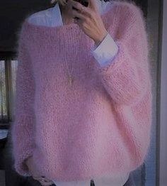 a woman taking a selfie in front of a mirror wearing a pink fuzzy sweater