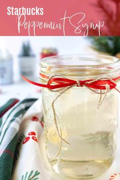 a jar filled with peppermint syrup sitting on top of a white table cloth