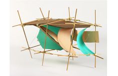 a sculpture made out of sticks and paper with a boat on it's back