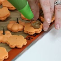 a person is decorating small cookies with icing