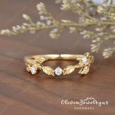 a gold ring with leaves and diamonds on it