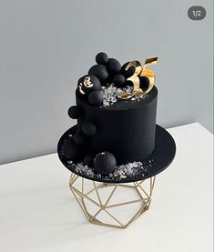 there is a black cake with gold decorations on it