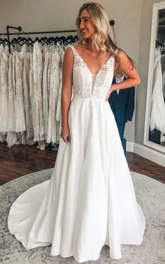 a woman standing in front of a wedding dress