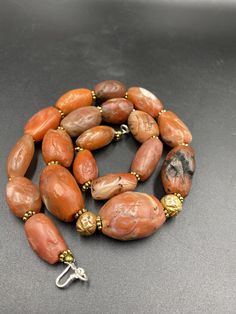 The Rare Unique PEMA RAKA Carnelian Amulet Prayer Beads Necklace From Himalayan Tibet The Age Of This Beads Are More than 1000 years Old As You Can See From Its Conditions Very Oily Smooth Skin Of This Pema Beads Some Gold Plated Wax and Gold Color Brass Beads Are Used As Spacers Rare Items For Collections Artisan Hand-strung Rondelle Beads, Carnelian Oval Gemstone Beads, Polished Oval Agate Beads Jewelry, Oval Agate Polished Beads Jewelry, Traditional Agate Gemstone Beaded Bracelets, Traditional Agate Beaded Bracelets With Gemstone Beads, Carnelian Oval Beads For Jewelry Making, Artisan Carnelian Beads For Jewelry Making, Artisan Amber Beads Hand-strung