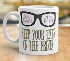 a white coffee mug with glasses on it says keep your eyes on the prize, stay focused