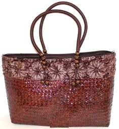 This cloth-lined tote is even more beautiful in person! Perfect for a day at the beach or a night on the town, featuring fabric flowers and decorative beading. 19" long, 10" tall, and 5" wide and zips shut.