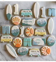 cookies decorated with different types of surfboards and vehicles on a marble counter top that says happy birthday to you