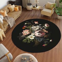 a living room filled with furniture and a rug covered in flowers on top of a hard wood floor