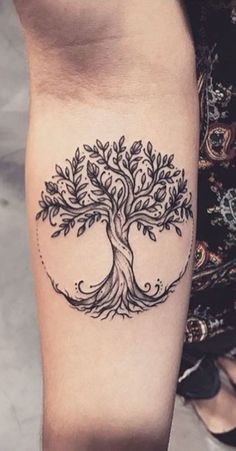 a black and white tree tattoo on the leg