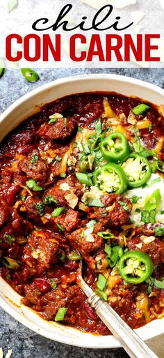 a bowl filled with chili con carne and topped with green peppers