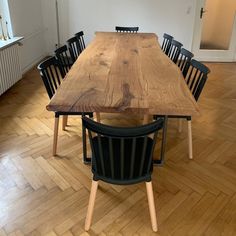 a wooden table with chairs around it on a hard wood flooring area in an empty room