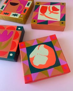 three brightly colored boxes are sitting on the table with each one's own artwork