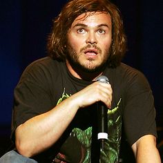 a man with long hair holding a microphone