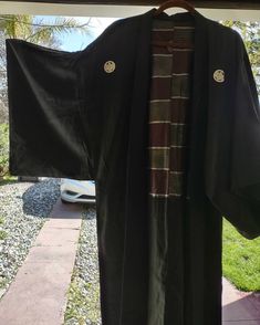 Vintage long black with striped lining kimono robe. Reversible and gender neutral. Know tags. It seems to be a fine quality silk robe. It fit me a little snug and I usually wear a size XL so I would say it's a large. Measurements will be be provided on request. I was told that the white emblems are a family crest of sorts. In excellent condition. Black Samurai Kimono With Kimono Sleeves, Black Long Cotton Kimono, Long Black Cotton Kimono, Traditional Black Kimono For Fall, Traditional Black Fall Kimono, Black Long Kimono For Fall, Long Black Kimono For Fall, Black Long Sleeve Samurai Kimono, Black Cotton Kimono With Kimono Sleeves