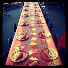 a long table is set up with plates and paper napkins for an autumn themed party