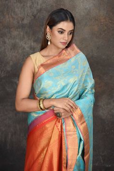 Beautiful light blue Kanjivaram brocade saree is a perfect drape for weddings and festive occasions. It has a red zari border and pallu. It comes with a matching blouse piece. Disclaimer: The shown stitched blouse on the model is for display purpose only. The saree comes with a matching blouse piece and finished with fall and piko. Light Blue Saree With Zari Weaving In Traditional Drape, Light Blue Saree With Zari Weaving, Traditional Light Blue Pre-draped Saree With Zari Work, Traditional Light Blue Art Silk Saree, Light Blue Saree For Diwali, Light Blue Traditional Wear With Self Design For Festivals, Festive Light Blue Traditional Wear With Pallu, Light Blue Art Silk Saree With Traditional Drape, Light Blue Traditional Drape Saree With Self Design