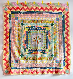 a multicolored quilt hanging on the wall