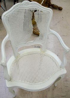 a white chair sitting on top of a hard wood floor next to a dead bird