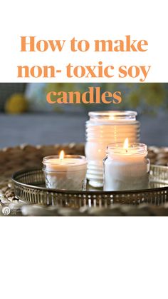 three lit candles sitting on top of a metal tray