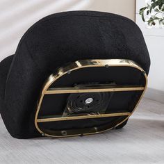 a black chair with gold trim around it and a cd case in the back pocket