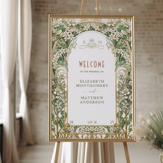 an ornate welcome sign is displayed in front of a brick wall and white drapes