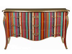 an ornate chest with multicolored stripes on the front and gold trimmings