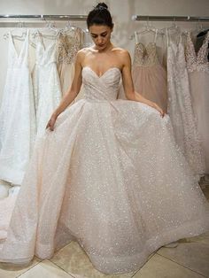 a woman standing in front of some dresses